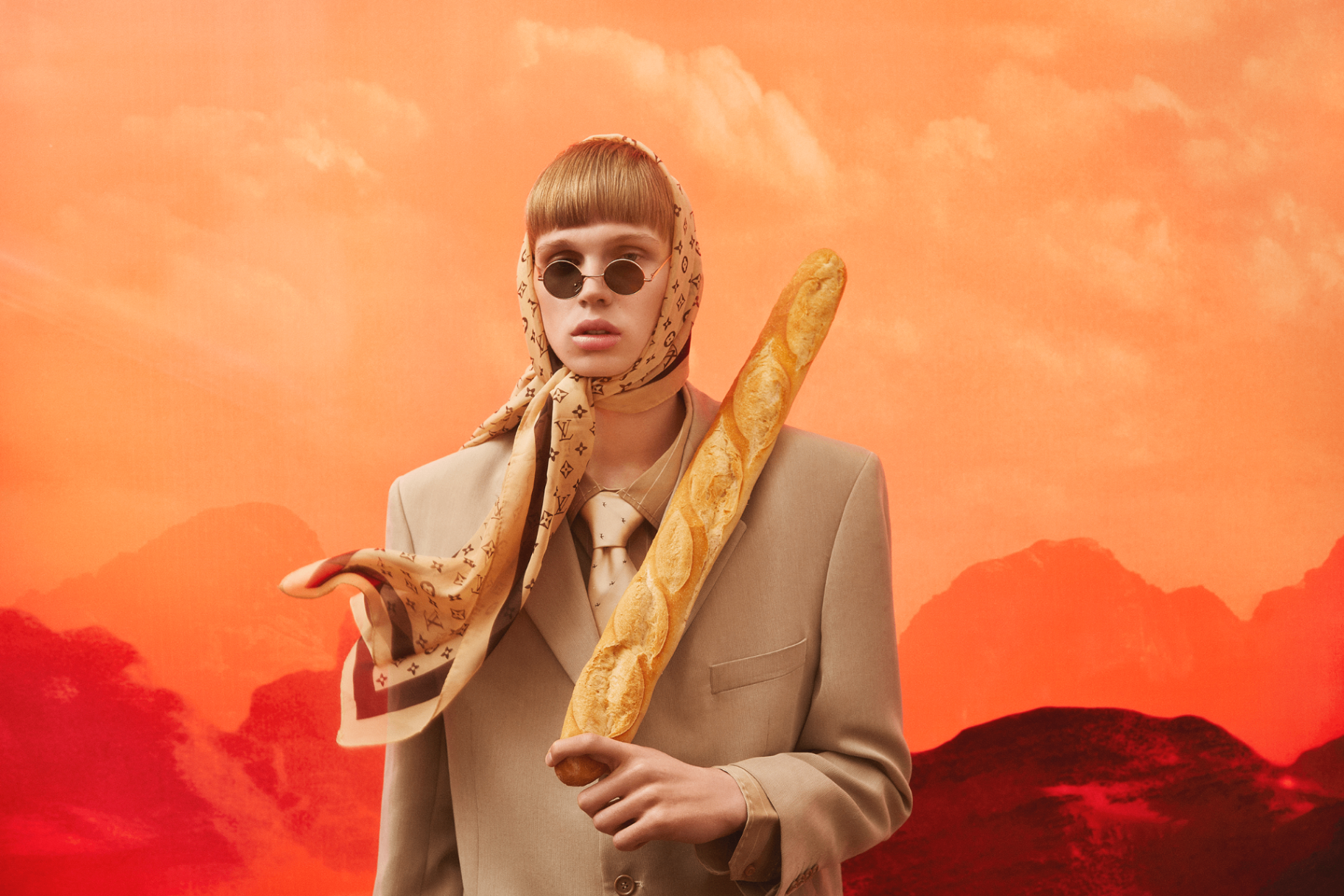 Surreal portrait with monogram scarf and baguette against orange sky