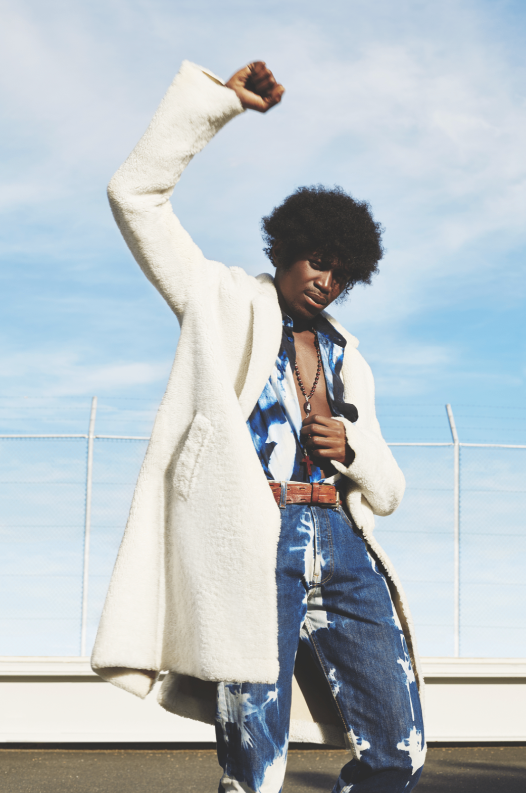 Full-length portrait in white coat against blue sky