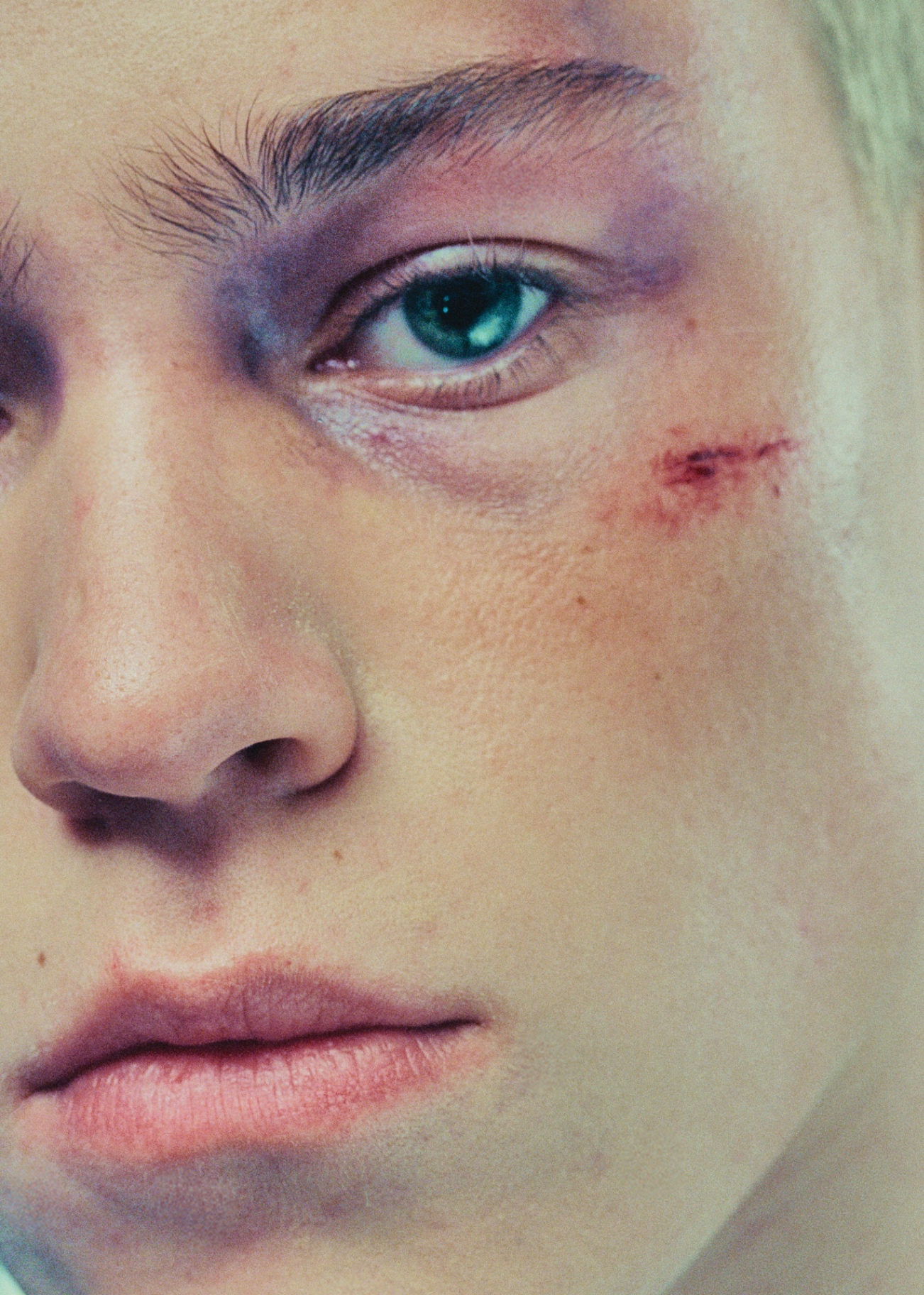 Extreme close-up of eye with makeup and facial scar detail