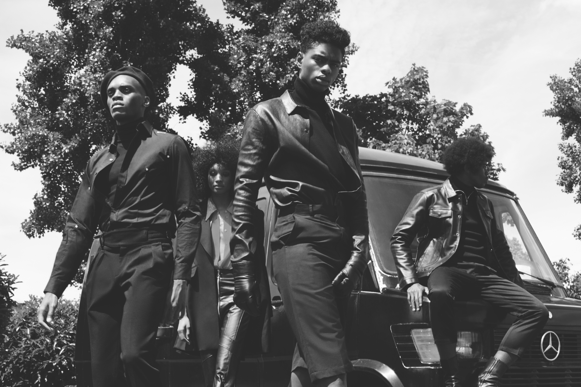 Black and white group portrait by a vehicle